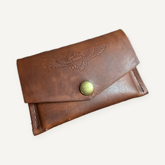 Horween English Tan leather pilot trading card pouch, closed, with stamped Naval Aviator wings and brass snap